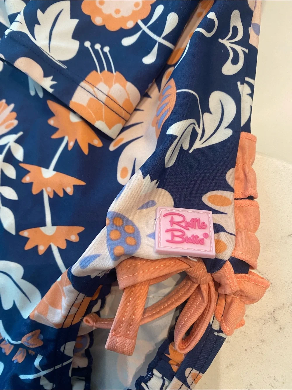 Ruffle Butts Navy Swimsuit with Peach Floral Accents